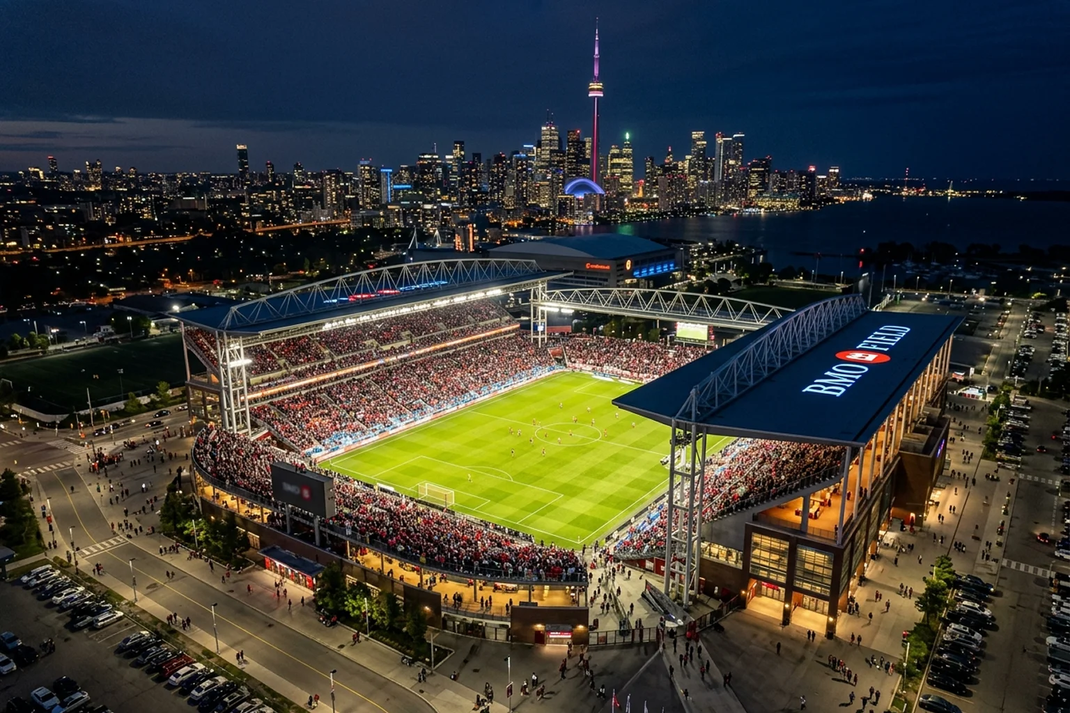 Aerial view of BMO Field in Toronto during a night match with the downtown skyline visible in the background